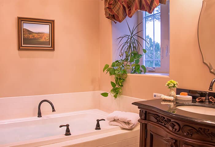 Elegant bathroom with cream walls and tile features dark brown wood tones on vanity