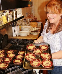 Caldwell House owner holding a tray of delicious homemade pies for Pie on the Pillow special